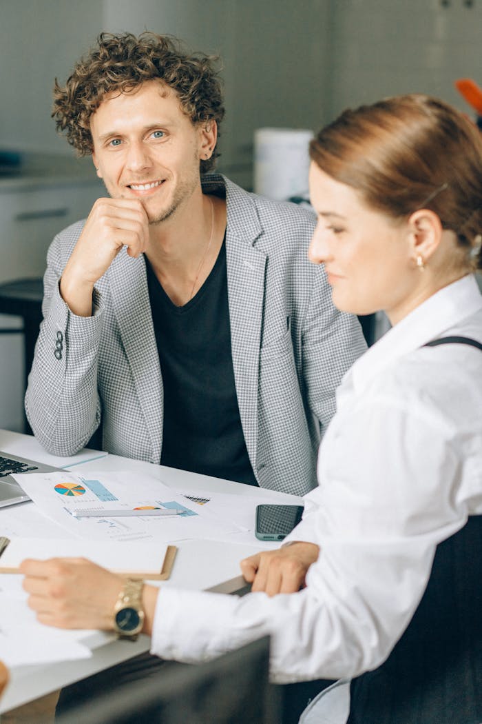 Two colleagues engaged in a business meeting in a modern office setting.